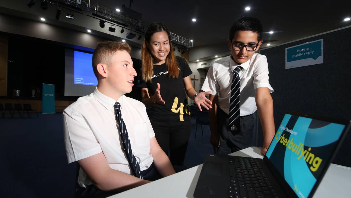 ONLINE SAFETY: St Stanislaus' College students Lachlan Pendarakis and Affan Usmani with Serena Lin from Optus. Photo: PHIL BLATCH