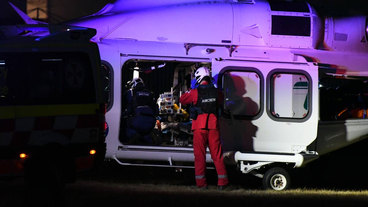 EMERGENCY: The patient is loaded into the Toll rescue helicopter at Hector Park on Sunday evening. Photo: CHRIS SEABROOK
