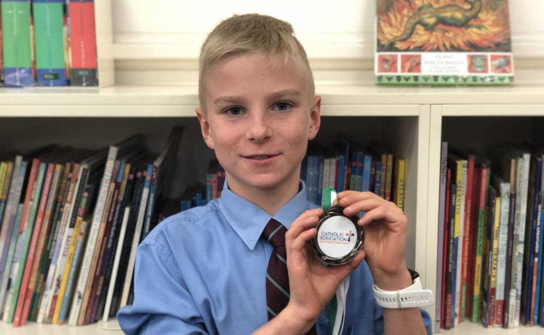 UNDER A SPELL: Holy Family student Emmett Jones with his medal.