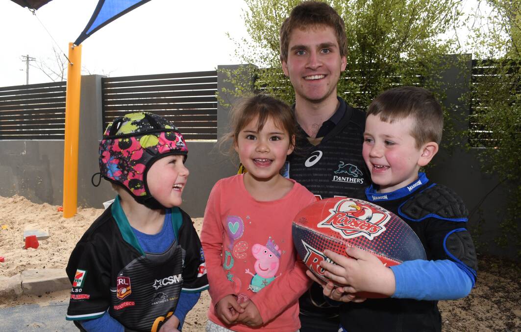 FOOTY COLOURS: Cooper Woodyatt, 5, Lara Cutmore, 4, and Jaxon Reed, 5, with Jenny's Kindergarten educator Kayne Knott promoting Footy Colours Day as a cancer fundraiser. Photo: CHRIS SEABROOK 082218colours