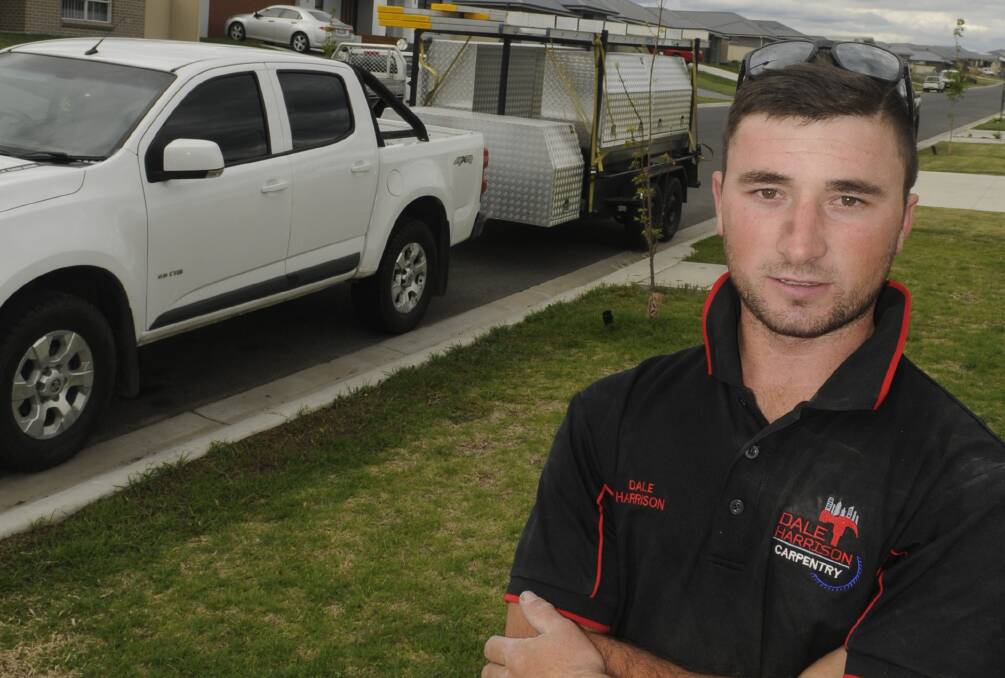 ANGRY: Carpenter Dale Harrison with his work ute and trailer that had tyres slashed early Tuesday morning. Photo: CHRIS SEABROOK 102517cslashd1b