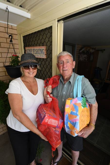 HAPPY CHRISTMAS: Volunteer,Susie Morgan with Chifley Village resident, Clive Coles with the Christmas hamper he received. Photo:CHRIS SEABROOK 121618cxhampr1a
