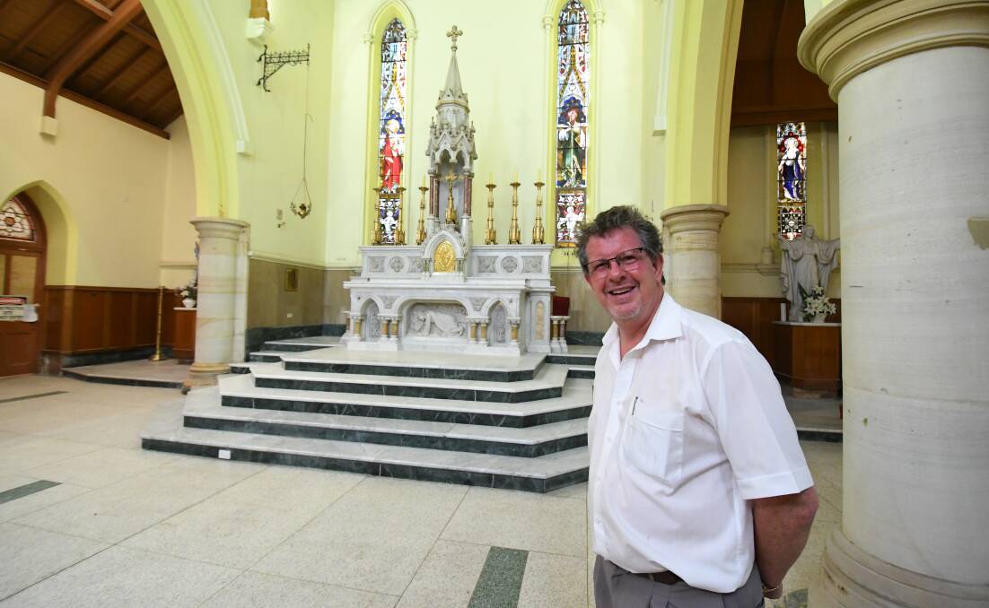 RESTORATION : Fr. Paul Devitt with the original altar in St. Michael's and St. John's Catholic Cathedral. Photo:CHRIS SEABROOK  121718calter1
