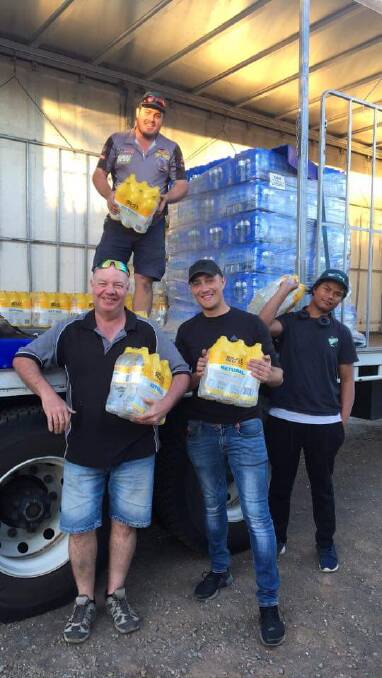 WATER DROP: Ethan, Wayne, Daniel and Ky, with some of the water dropped off out west by Corrections NSW staff who volunteered their time.