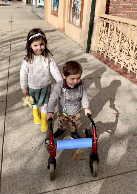 RACING AROUND THANKS TO A COMMUNITY EFFORT: Alby taking his first walk with his big sister Edith in his new walker.