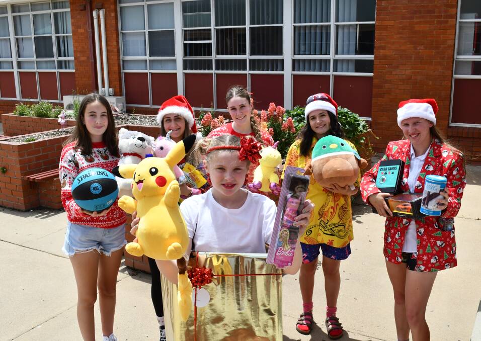 Paige Townsend (at front) with Juliet Phillips, Hanna Alibeygi, Savannah Beard, Lucia Church and Evie Scott and some of the gifts donated to the Christmas appeal.