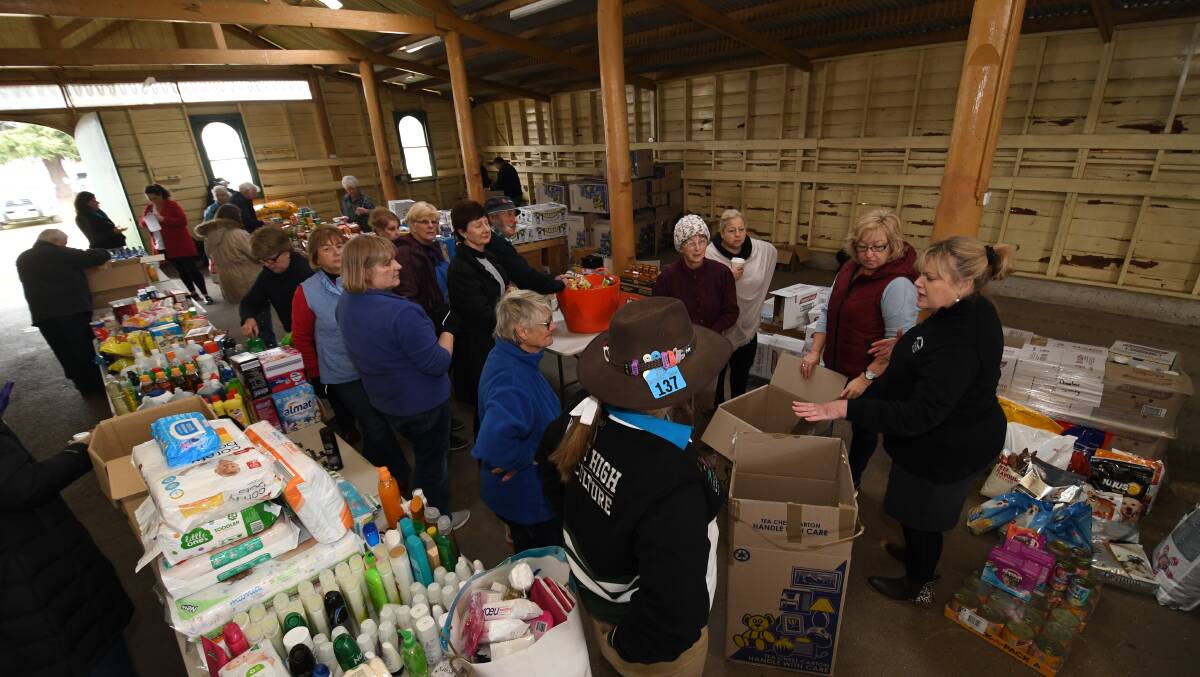 HELPING OUR FARMERS: Volunteers at the Bathurst Showground packing care boxes for local farmers struggling in the drought.