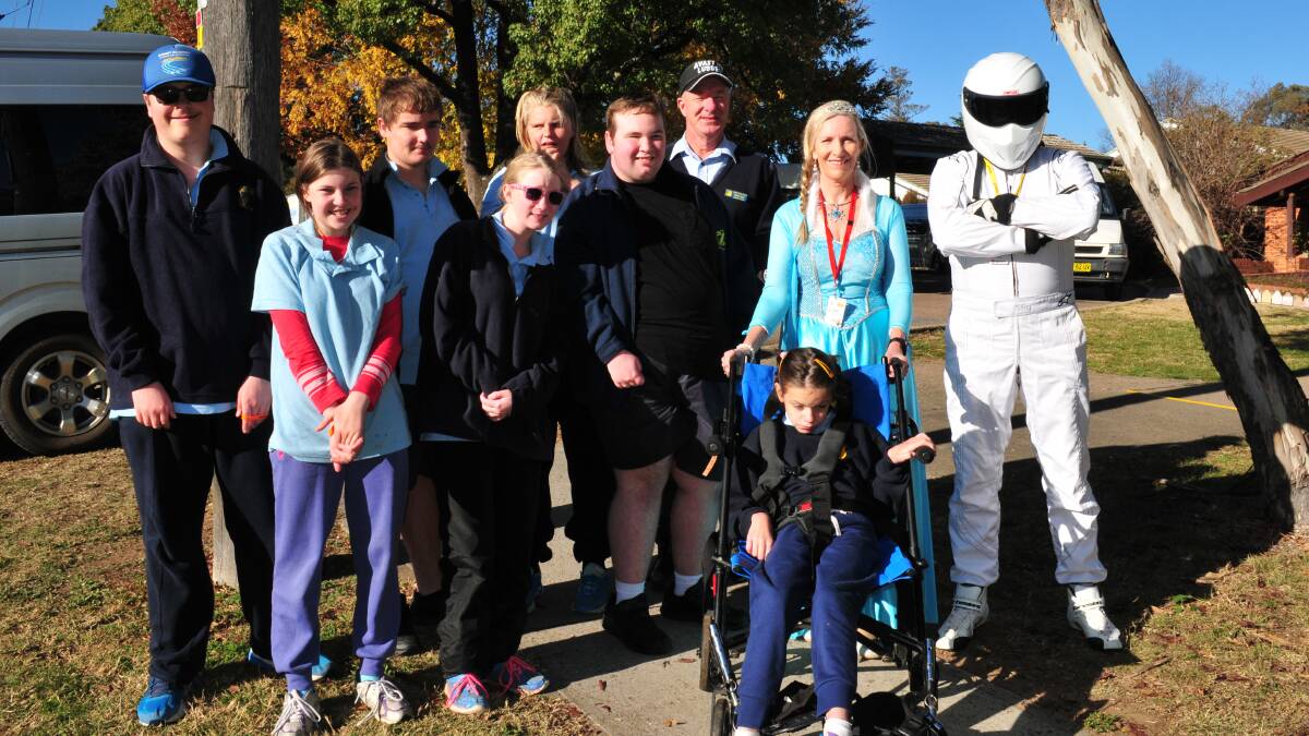 DONATION: Wayne (the Stig) Sexton and his wife Lee (as Anna), with Terry Neal from Carenne, and students from Carenne Public School, during a visit from the Variety Bash.