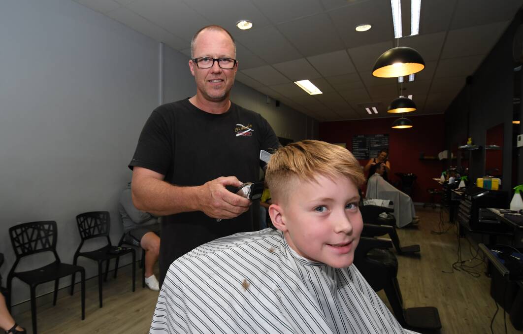 BARBER CELEBRATES 30 YEARS: Barber, John O'Shea on the job since 10th December 1988, cutting Lachlan Wright's hair. Photo:CHRIS SEABROOK  121118c30cuts