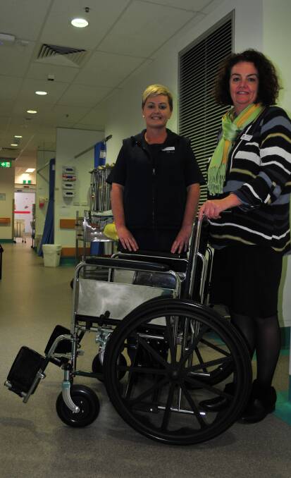 RARE FIND: Bathurst Base Hospital registered nurse Melanie Lund and general manager Cathy Marshall with one of the hospital's few remaining wheelchairs. 