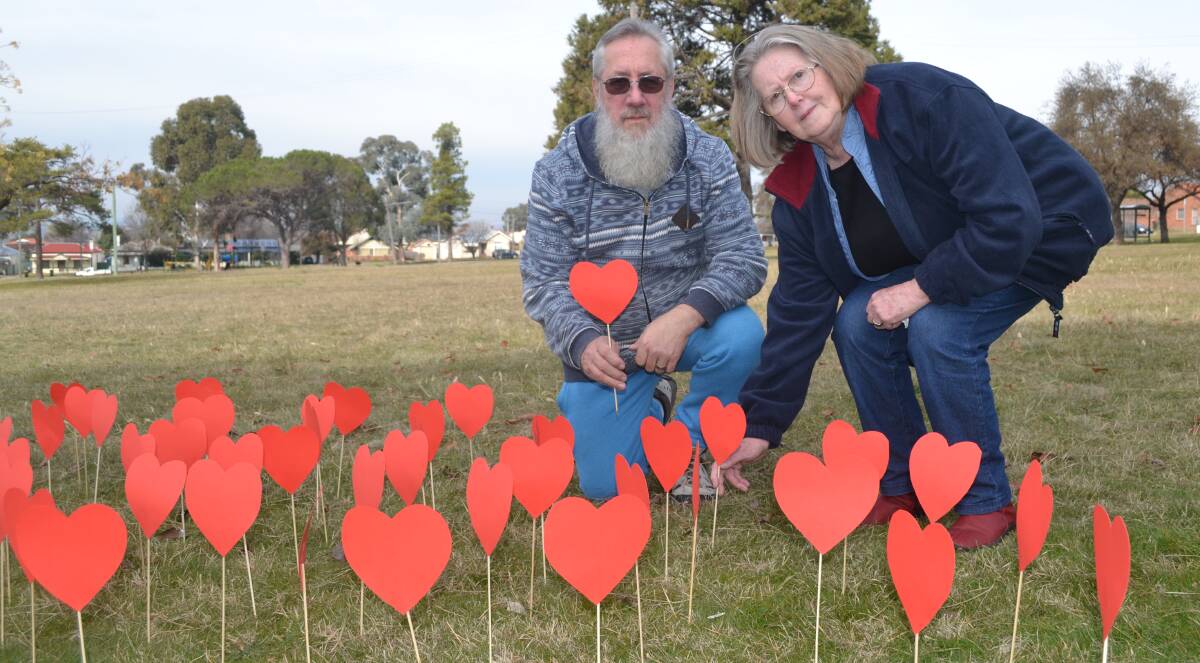 FOR THE VICTIMS: Wayne and Carole Nielsen travelled from Wollongong for the victim's vigil in Centennial Park on Friday. Each red heart represented one of the 160 victims.