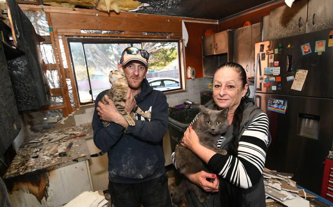 THANKS: Resident, Luke Maloy (38) with 'Molly' and neighbour, Lynn Dwyer with 'Toby' in the burnt-out Kitchen. Photo:CHRIS SEABROOK 072319cfire1