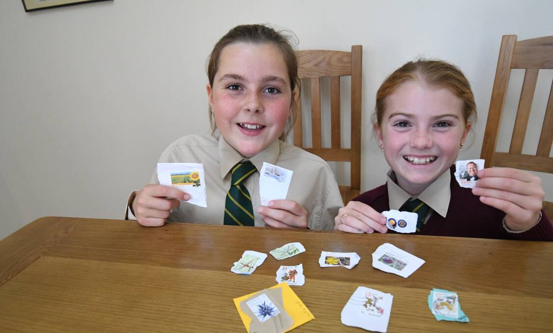 STAMP COLLECTING: Assumption School Year 6 students Annabelle Jones with Ashley Larsen collecting stamps for East Timor. Photo:CHRIS SEABROOK 052318cstamps
