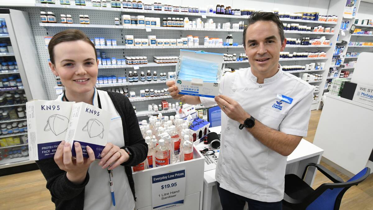 FACE OFF: Jessica Morgan-Thomas with Chemist, Marcus Heiner at Capital Chemist holding a collection of face masks. Photo:CHRIS SEABROOK 072220capital1