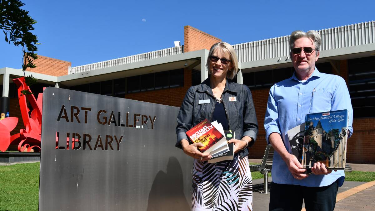 BOOK SALE: Tracey Platt (library assistant) with Shane Summerton from Bathurst Regional Library, with some of the books which will be for sale.