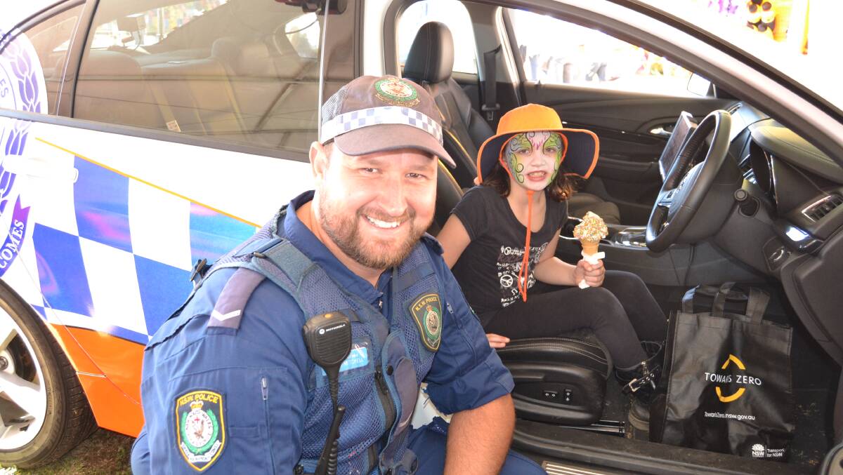 COMMUNITY ENGAGEMENT Constable Simon Mitchell, from the Joint Traffic Taskforce, with nine-year-old Megan Harper from Perthville, having a look at a highway patrol car in the police tent at the show.