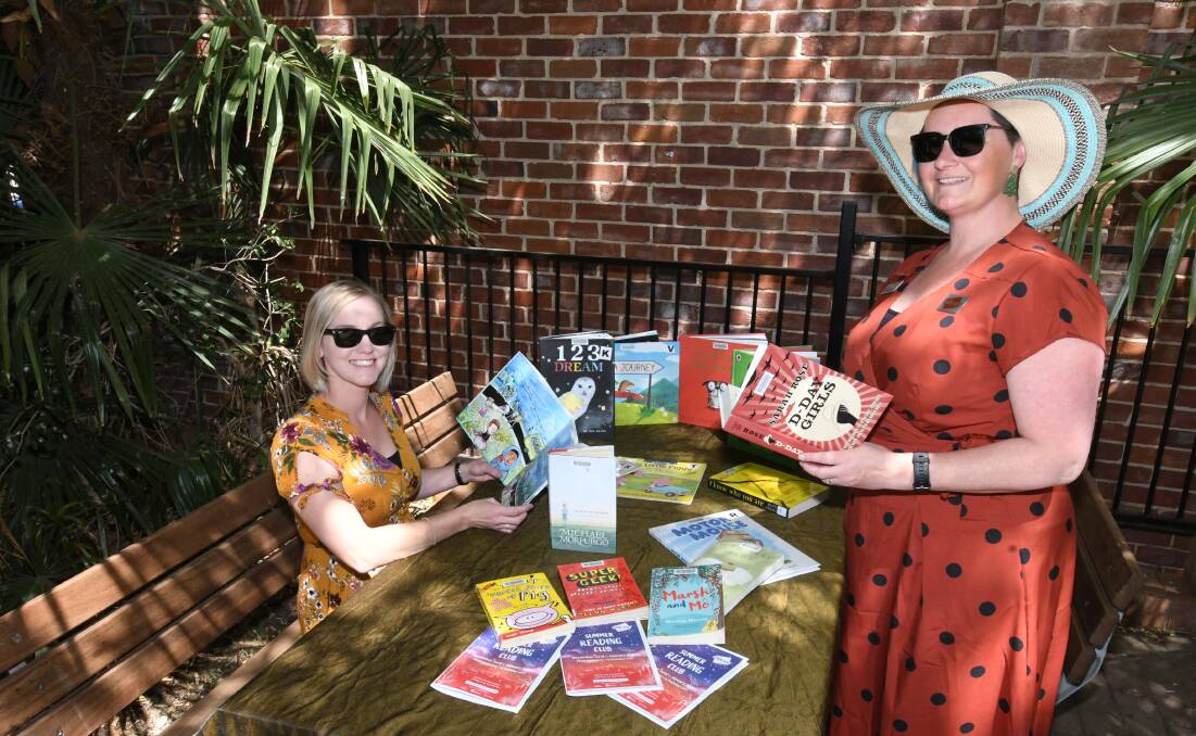 SUMMER READING: Natalie Conn (program officer) with Rhiannon Mijovic (program assistant) promoting the library's reading club.
