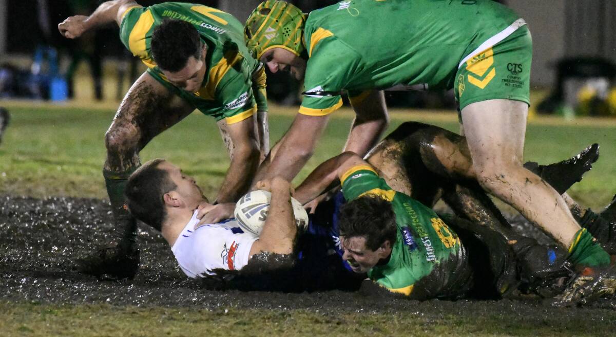 WET AND WILD: St Pat's prop Luke Single is stopped in a tackle by Orange CYMS rivals Daniel Mortimer, Cam Jones and Pat Williams. Photo: JUDE KEOGH.