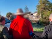 A still taken from footage of the arrest of a 63-year-old man charged with more than 70 historical sex offences. Picture by NSW Police