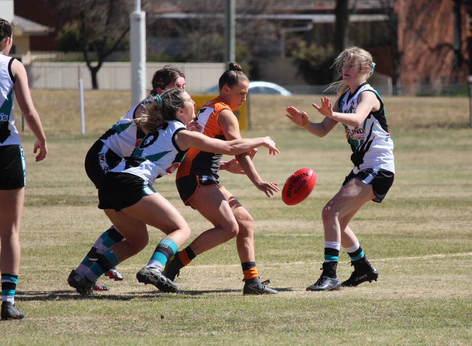 CONTEST: Bathurst Giants' Tamara Thompson is surrounded by a pack of Bathurst Bushrangers players while trying to regather the ball. Photo: MAX STAINKAMPH