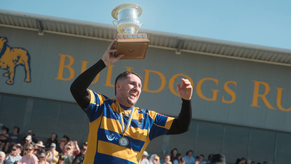 Zac Mcgowan lifts the Central West Rugby Union third grade trophy aloft after the Bathurst Bulldogs' win on Saturday. Picture by James Arrow.