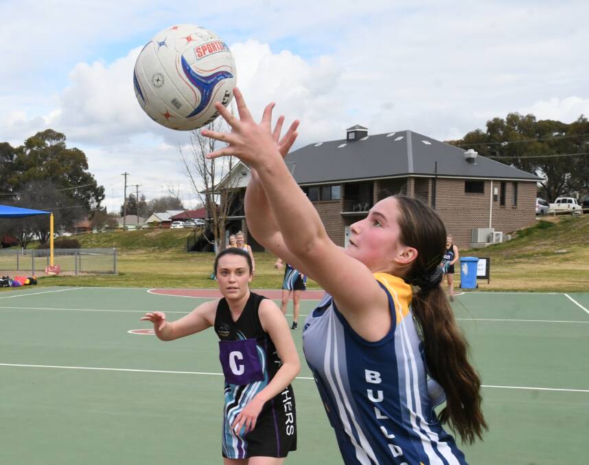 TARGETING A TEAMMATE: Bulldogs Verdelho centre Molly Dowling sends a pass high into the circle as Panthers' Abby Stammers watches on. Photo: CHRIS SEABROOK 072520cnetball2