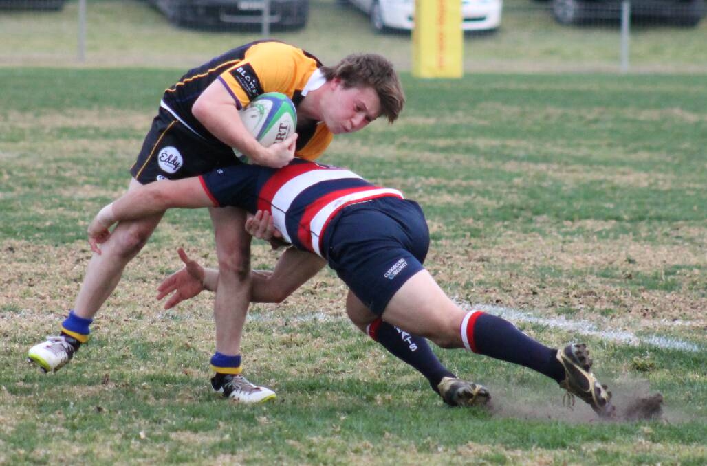 ALL LEVEL: CSU's Ben Reading-Thompson is wrapped up by a Mudgee Wombats opponent in Saturday's Blowes Clothing Cup contest. The match finished as a 22-all draw.
