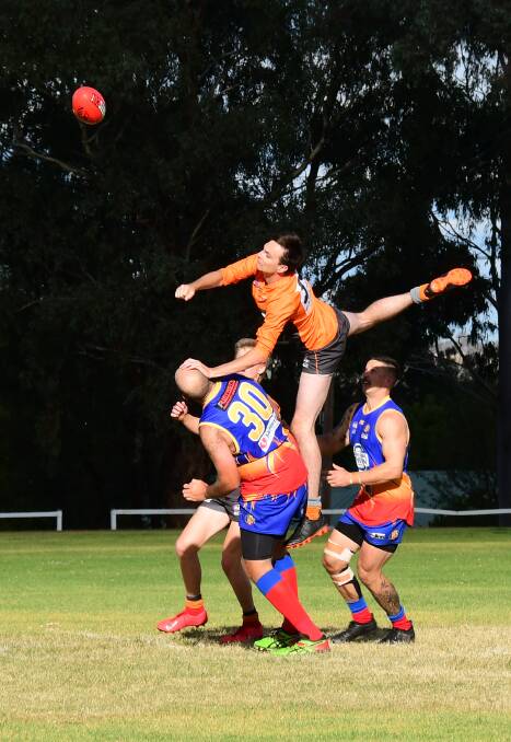 FIST: Bathurst Giants' James Kennedy soars over the top of several Dubbo Demons opponents to punch the ball clear in Saturday's match. Photo: AMY MCINTYRE