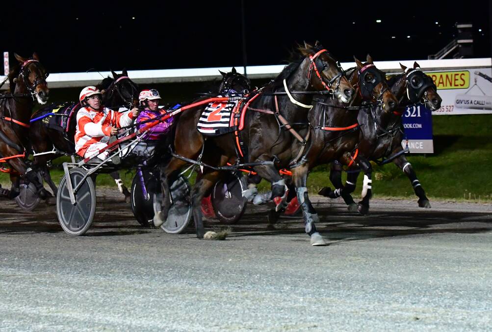 HERE I COME: Eagle Commander (closest to camera) hits the front in Wednesday night's heat to claim the upset victory for trainer-driver Nathan Hurst. Photo: ALEXANDER GRANT