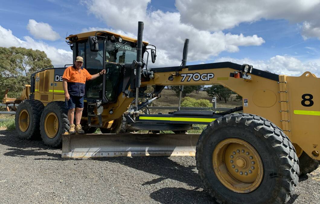 Robbie Wallace and the grader which saved lives and property. Picture: Peter Brewer