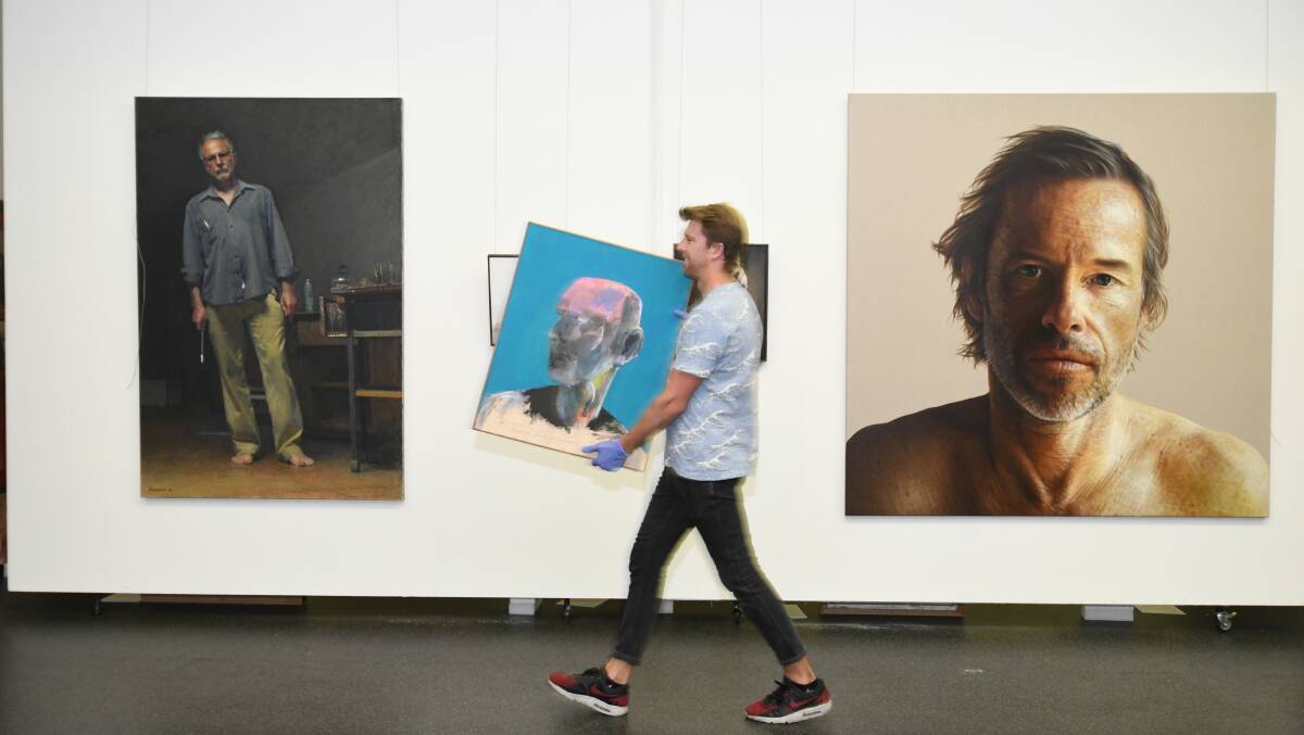 PRIZED PORTRAITS: Mike Allen was part of the installation team responsible for hanging the Archibald Prize entries at the Orange Regional Gallery. Photo: JUDE KEOGH 0205jkarchie1
