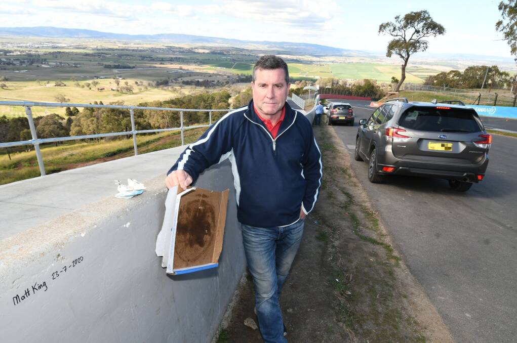 ONGOING PROBLEM: Warren Aubin showing some of the rubbish that is commonly left on top of Mount Panorama, just near the Esses. Photo: CHRIS SEABROOK 080420ctrash1