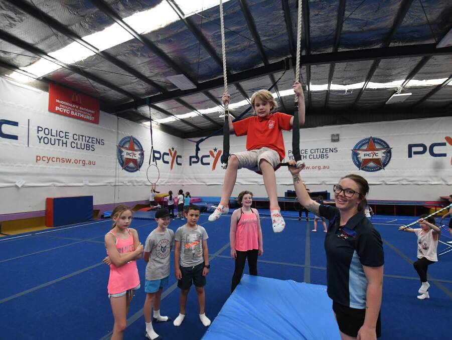 UP IN THE AIR: Bathurst PCYC activities officer Taylor Dawson helping Gabrielle Ferguson, 11, learn circus skills. Photo: CHRIS SEABROOK 010219cpcyc2