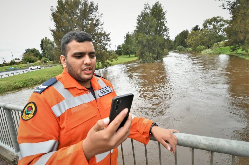 MONITORING: Flood technician Josh Besterwitch on the phone to his duty officer after appraising the Macquarie River from the low level bridge. Photo: CHRIS SEABROOK 030822clowlevel3