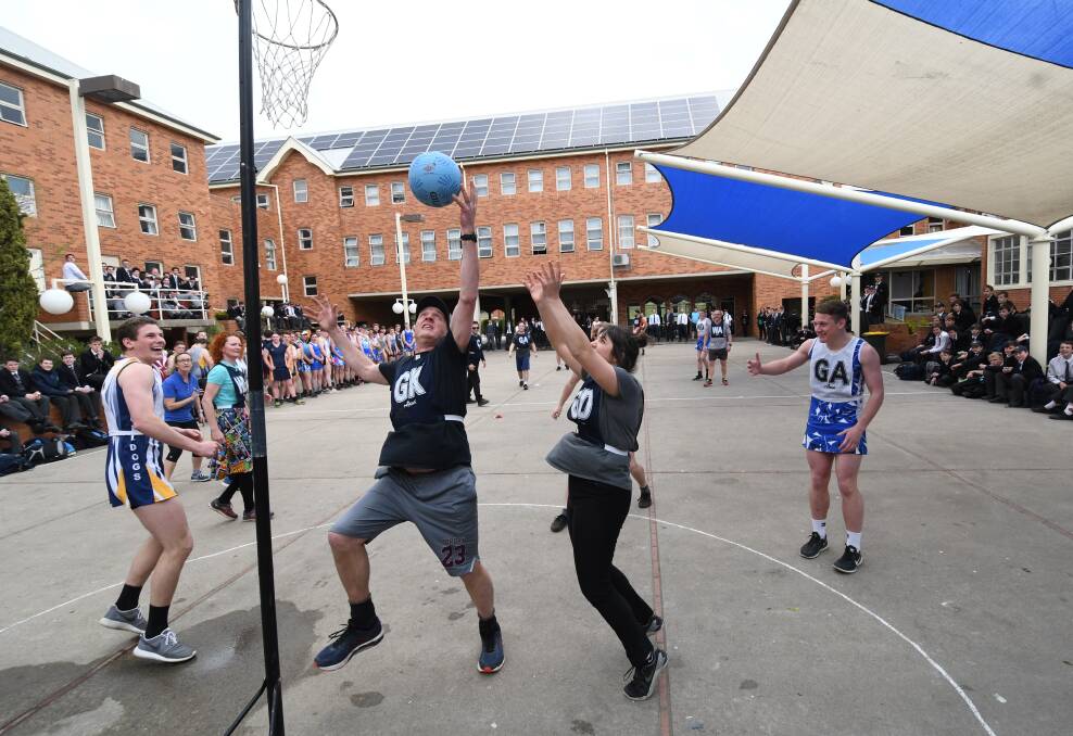 PLAYING TO WIN: Teacher Michael Germech in action during the staff versus students netball game. Photo: CHRIS SEABROOK 092418csscnet1