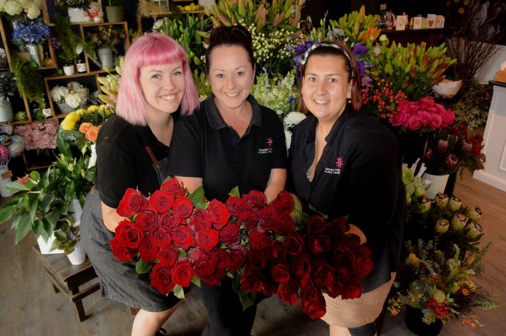BUSY: Anna Smith, Vanessa Pringle and Rebecca Owen from Vanessa Pringle Floral Designs with red roses. Photo:RACHEL CHAMBERLAIN 020720rcvday