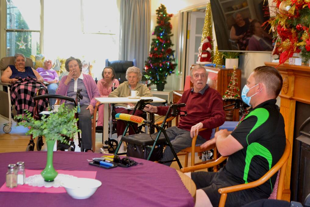 SHARING STORIES: Super2 driver Jon McCorkindale, of Dial Before You Dig Racing, talking to residents at Macquarie Care Centre on Friday. Photo: RACHEL CHAMBERLAIN 120321rcvisit