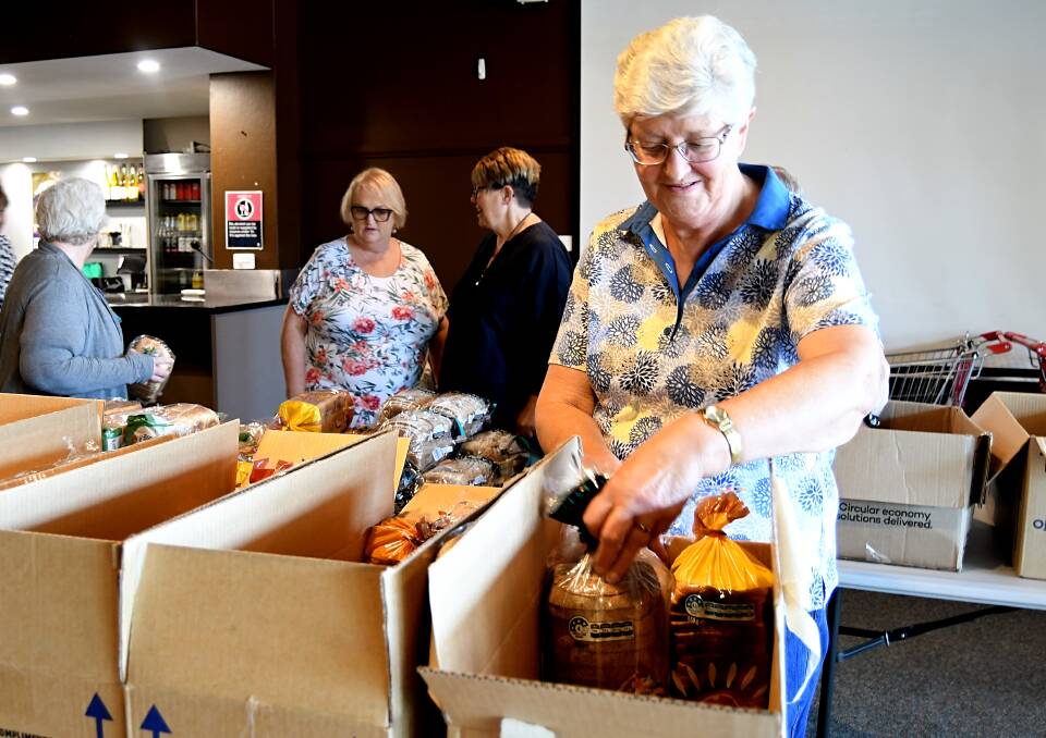 Volunteers at The Little Pantry packing bread into boxes of groceries. Picture by Rachel Chamberlain