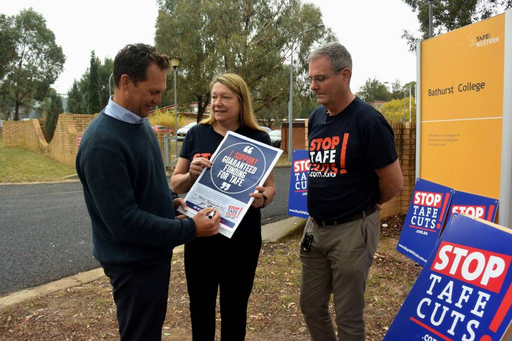 COMMITMENT: Labor candidate Jess Jennings signing the pledge for NSW Teachers Federation organisers Annette Bennett and Robert Long. Photo: RACHEL CHAMBERLAIN 051019rctafe