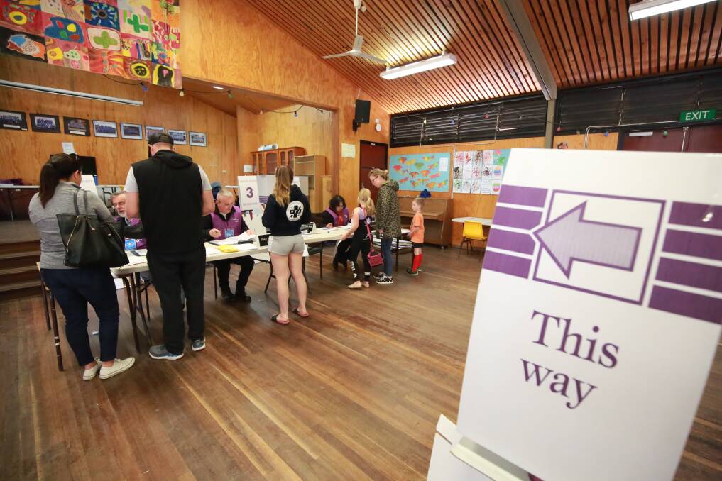 MAKING IT COUNT: Voters getting their names marked off the electoral roll at Eglinton Public School today. Photo: PHIL BLATCH