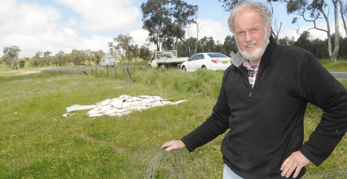 DISAPPOINTED: James Stewart's father, Peter Stewart, with asbestos laden material left behind at the propery after a road accident recently. Photo:CHRIS SEABROOK 101116cfence1
