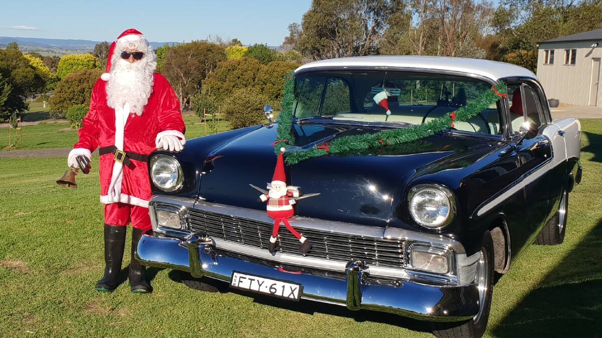 TAKING A SPIN: Santa Claus was out and about on Christmas Eve, spreading cheer in this decorated 1956 Chevy Bel Air. Photo: ROS BUHAGIAR