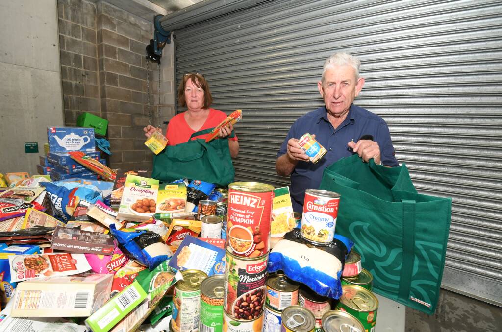 LOTS TO DO: Volunteers Moira Johnson and Jim Wilds with some of the donations that will be packed into hampers for the 2BS Bathurst Lions Christmas Miracle Appeal. Photo: CHRIS SEABROOK 121019cxhamprs
