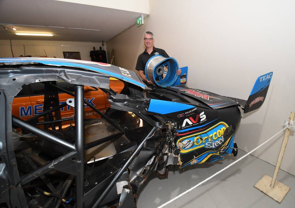 ON DISPLAY: National Motor Racing Museum manager Brad Owen with the wrecked Ford Falcon of Chaz Mostert, which continues to be a popular attraction. 