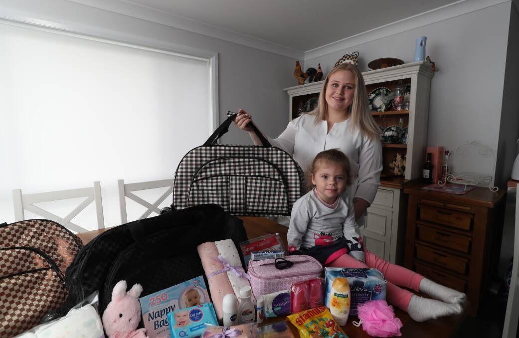 ALL-IN-ONE: Meg James and her two-year-old daughter Hallie James, showing the contents of the bags. Photo: PHIL BLATCH 033119pbbag3