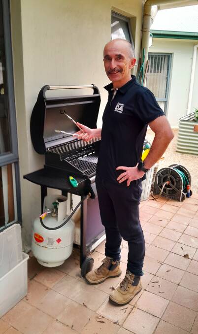 Peter Hickey, an advocate in the Disability Advocacy NSW Bathurst office, standing by a barbecue with tongs in hand. Picture supplied