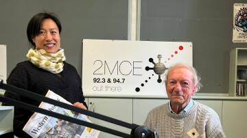 Volunteers Miao Li and Chris Bacon sitting behind the 2MCE panel. Picture supplied