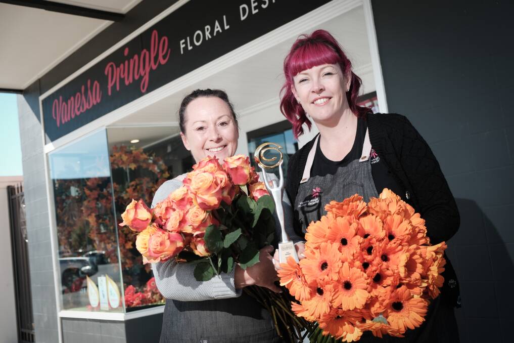 Vanessa Pringle and Anna Smith from Vanessa Pringle Floral Designs with bouquets of orange flowers and their Australian Small Business Champions trophy. Picture by James Arrow
