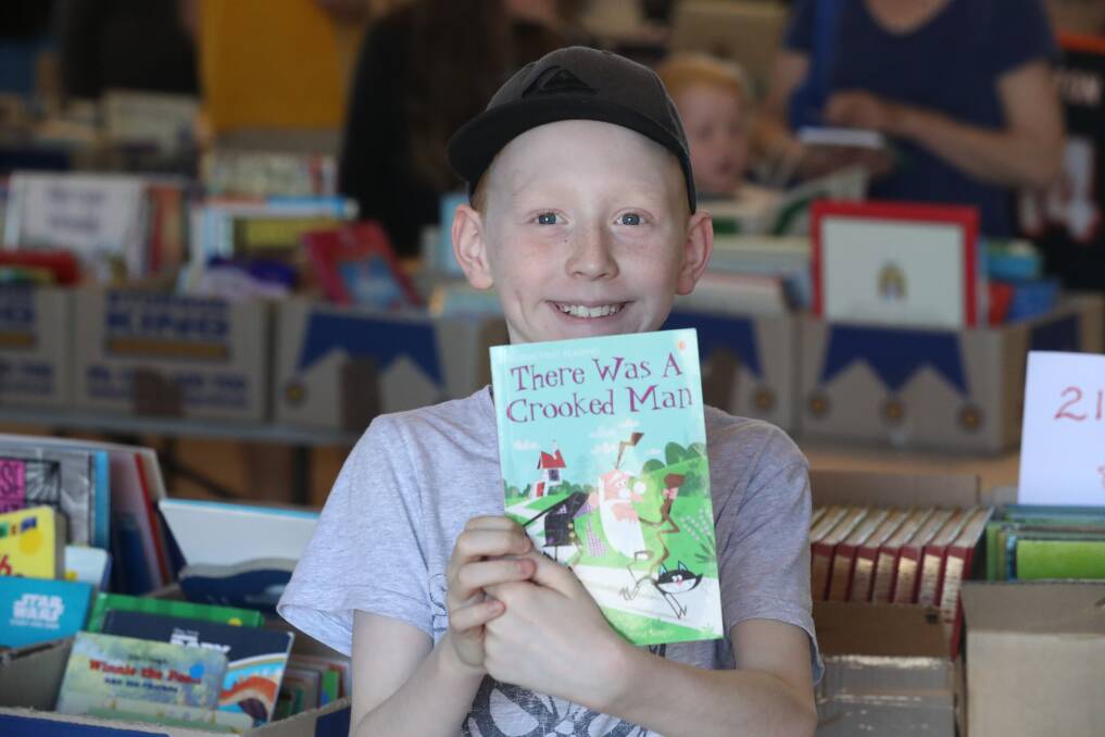 HAPPY CUSTOMER: Nine-year-old Lachlan Stephen found this gem at the Lifeline Book Fair on Sunday morning. Photo: PHIL BLATCH 102118pbbook1