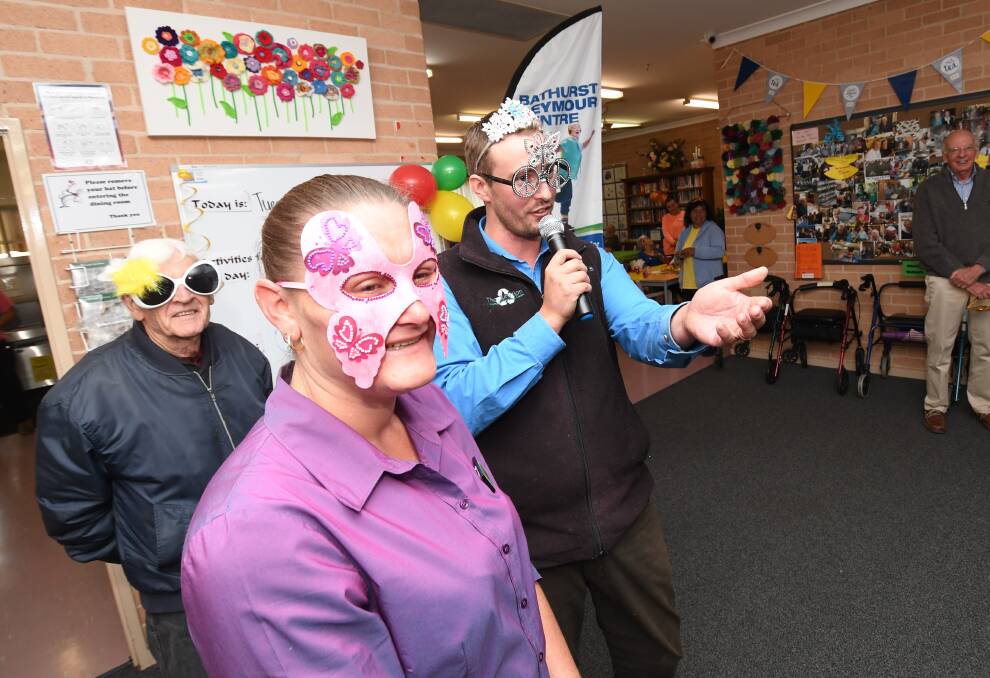 ALL IN GOOD FUN: Quebec Kobezda with Elliot Redwin, from the Junktion, during the auction of masks and glasses at Bathurst Seymour Centre's Biggest Morning Tea on Tuesday. Photo: CHRIS SEABROOK 050818cseymr1